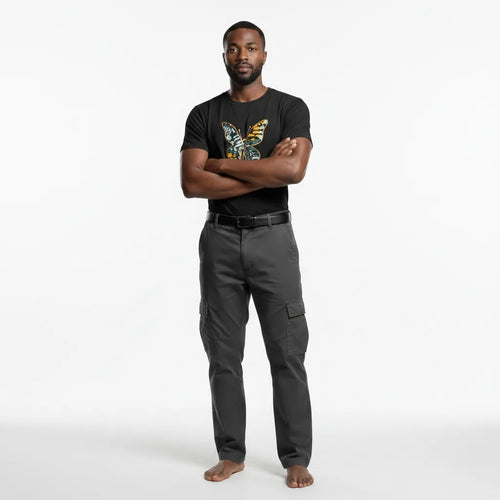 Man wearing a black t-shirt with a colorful design and gray pants on a white background