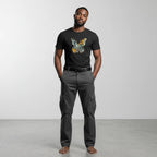 Man wearing a black t-shirt with a butterfly design and gray cargo pants on a white background