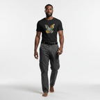 Man wearing a black t-shirt with a colorful butterfly design and gray cargo pants on a white background